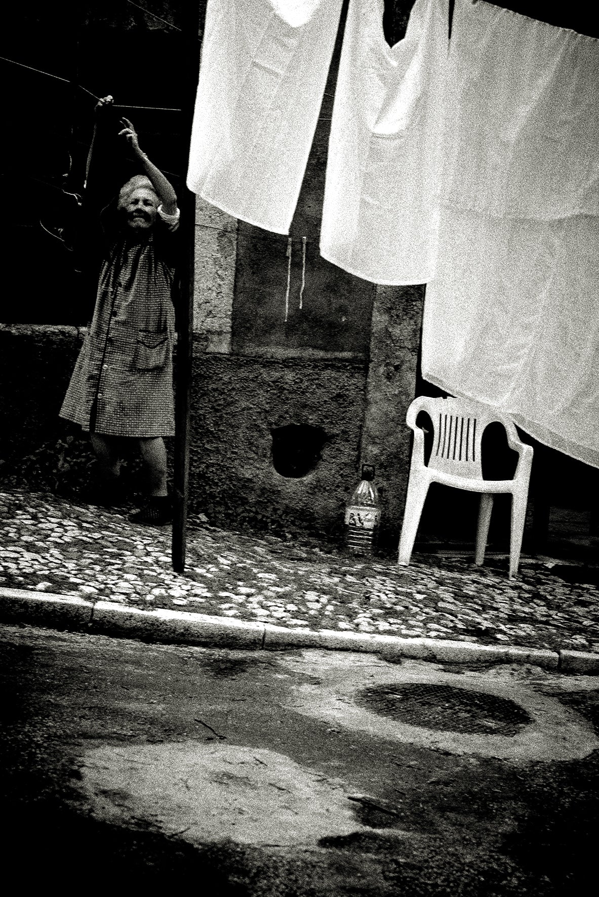 Woman hanging up laundry, Lisbon by Andreas H. Bitesnich, limited edition photography